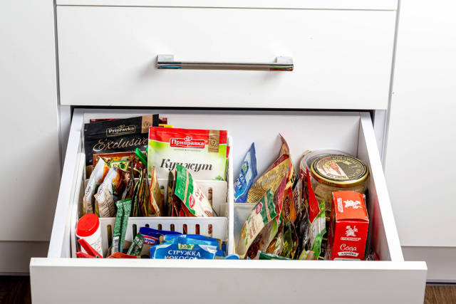 Open kitchen drawer with various spices
