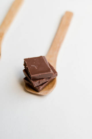 Milk Chocolate Pieces in a wooden spoon