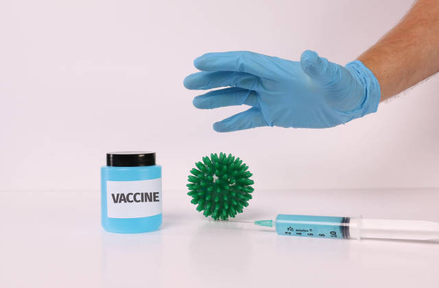 Hand in medical gloves over Coronavirus bacteria