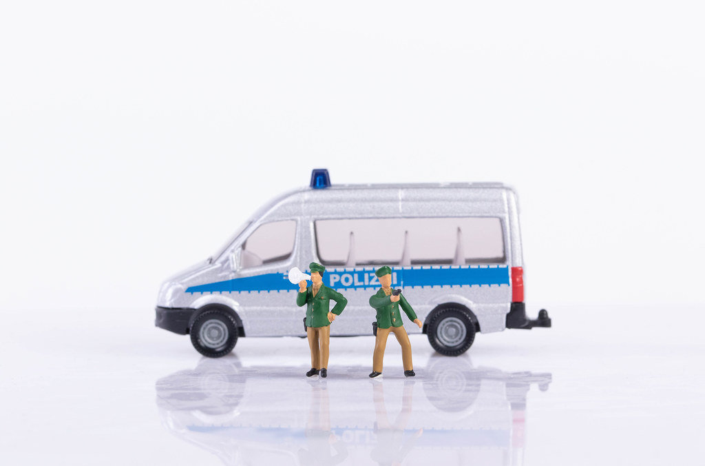 Two policeman and police car on white background