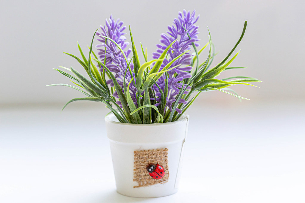 White bucket with purple artificial flowers - Kostenloses Foto auf