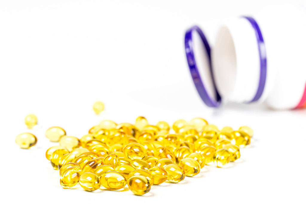 Yellow capsules on a white background. Vitamin A, treatment of vitamin deficiencies