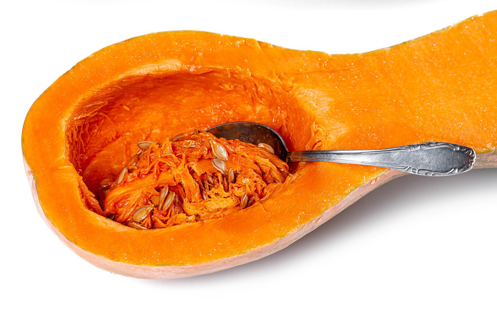 Fresh raw half orange pumpkin with seeds and spoon
