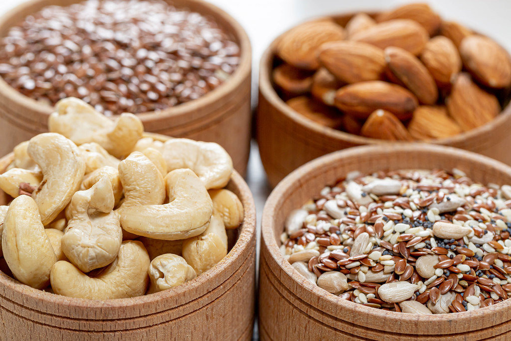 Close-up of cashew nuts, almonds and various seeds in wooden bowls