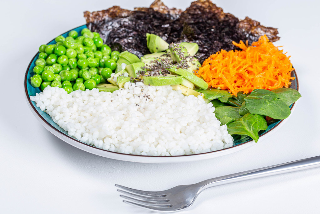 Rice with fresh vegetables, spinach, Chia seeds and nori on a white background