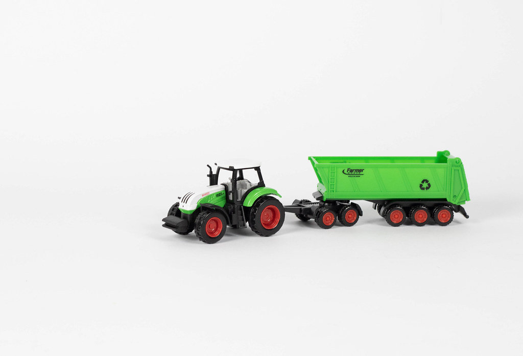 Traktor mit Anhänger vor weißem Hintergrund