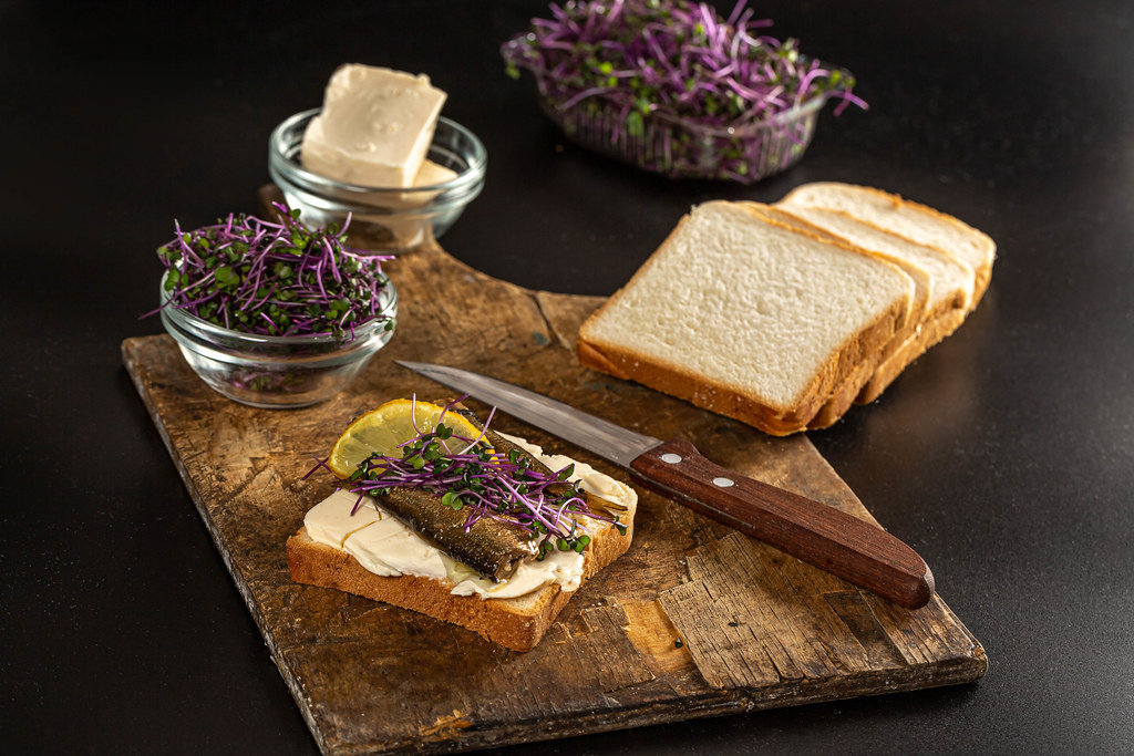 Sandwich with fish conserve, cabbage sprouts and lemon