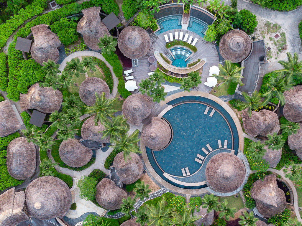 aerial image of spa area with circular pools and sunshades made of bast on tropical island Mahé, Seychelles