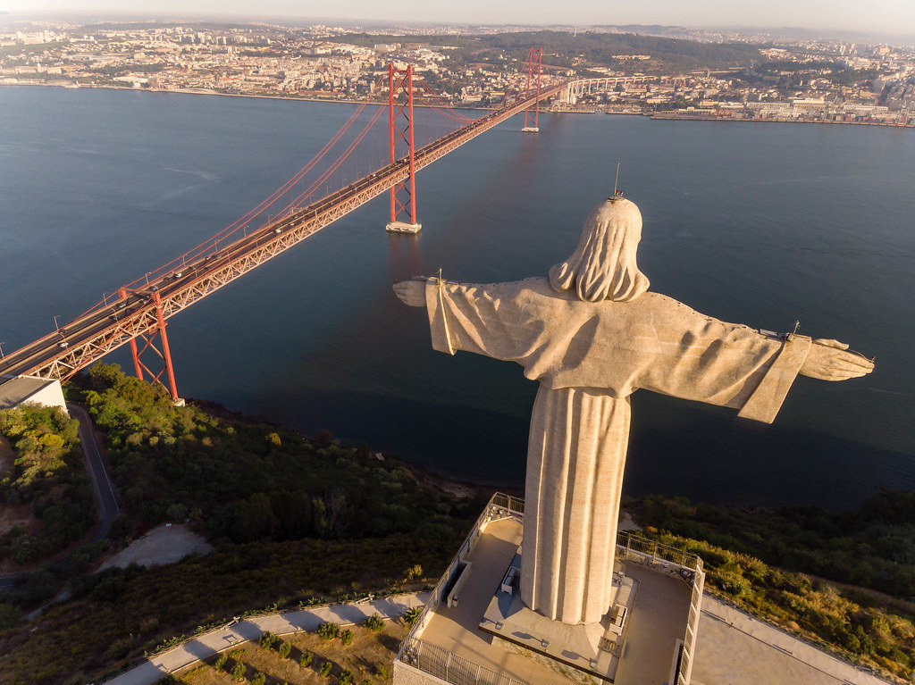 Luftaufnahme von hinten Cristo Rei Statue und Ponte 25 de Abril Brücke in Almada Lissabon - Kostenloses Foto auf ccnull.de