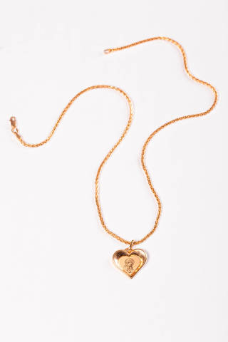 Gold chain and pendant in the shape of a heart on a white background