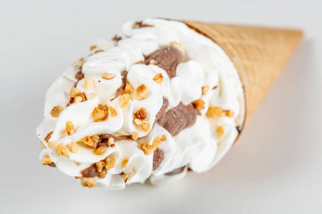 Ice cream with chocolate and nuts in a waffle cone