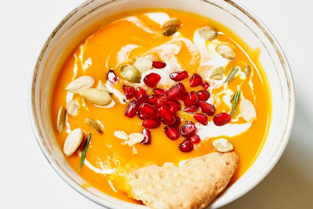 Fresh pumpkin soup topped with pomegranate seeds