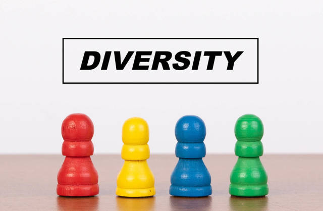 Diversity concept with four pawn figurines on table