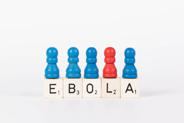 Word Ebola written on wooden blocks with pawns in various colors on white background