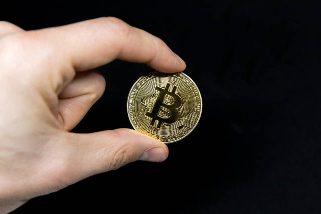 Bitcoin-Münze vor schwarzem Hintergrund