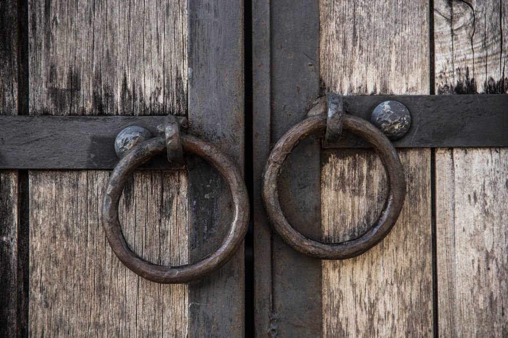 Altes Holztor mit geschmiedeten Verstärkungen