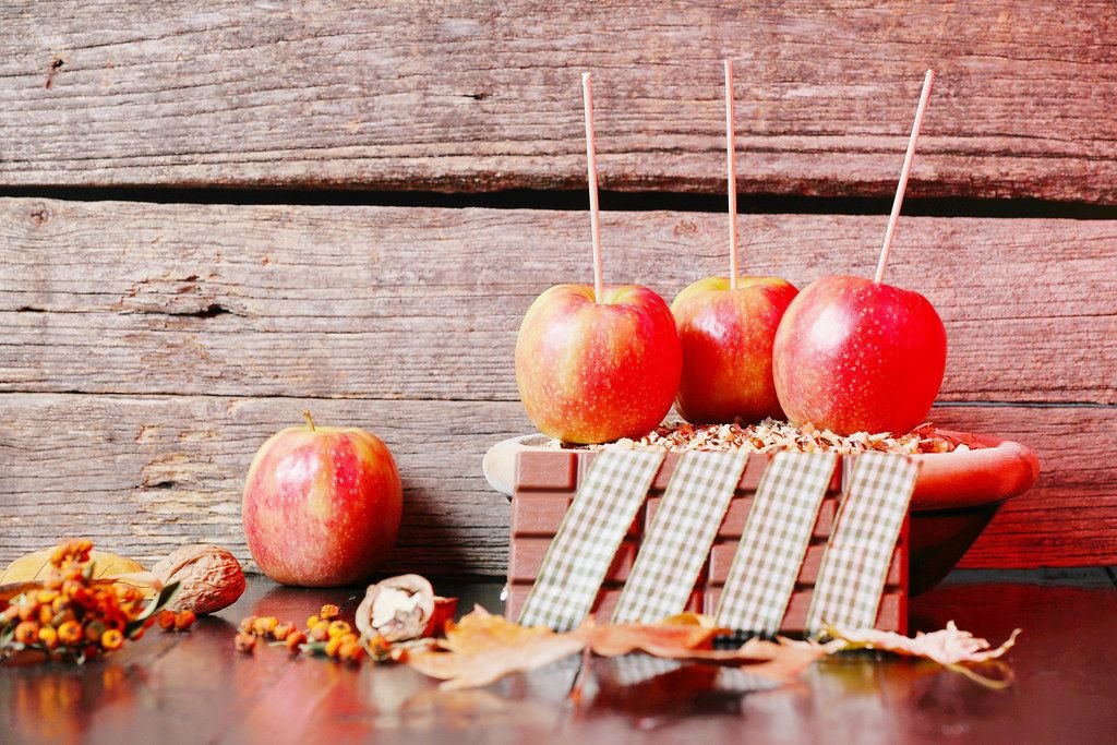 Äpfel und Schokolade zu Weihnachten umgeben von Nüssen und Blättern