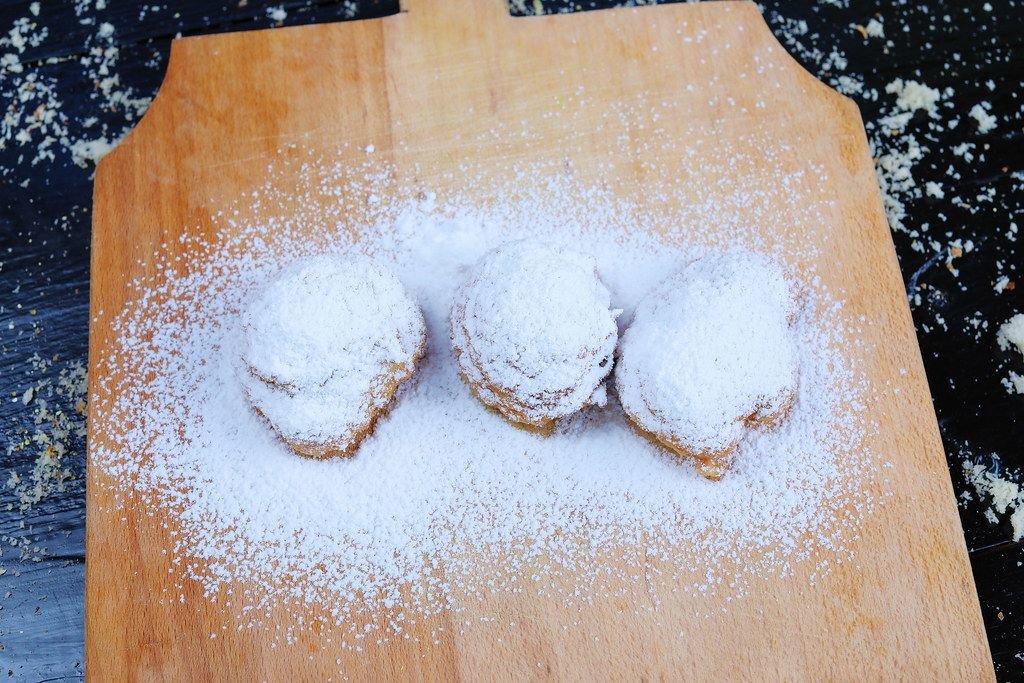 Doughnuts with powdered sugar on wooden background (Flip 2019)