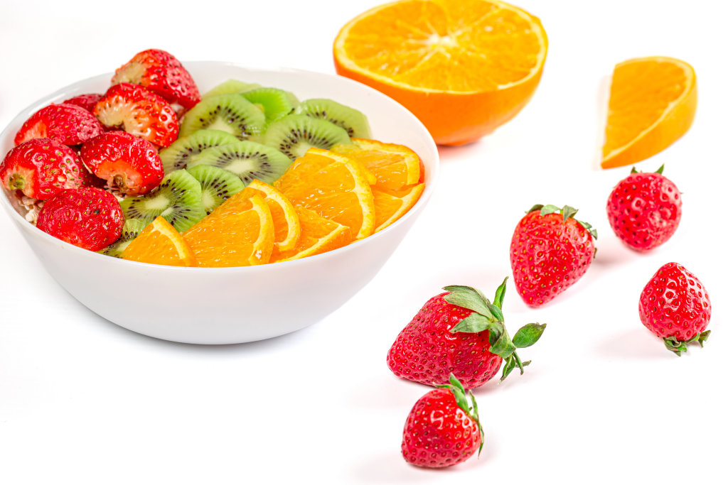 Healthy food - oatmeal with fresh strawberries, orange and kiwi