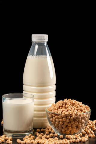 Milk in a bottle and in a glass on a dark background with chickp