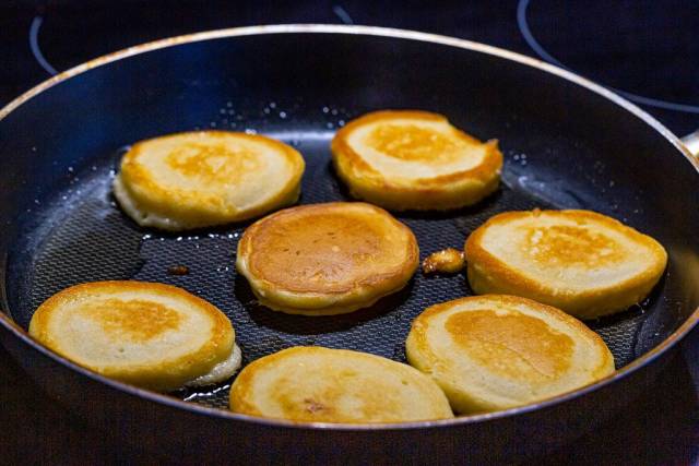 Kleine Pfannkuchen in einer Pfanne machen