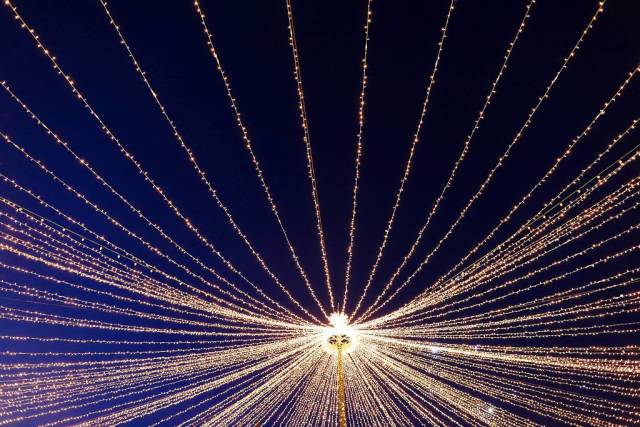 Weihnachtsbeleuchtung vor blauem Himmel