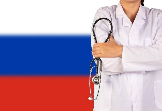 Russische Gesundheitssystem symbolisiert durch die Nationalflagge und eine Ärztin mit Stethoskop in der Hand