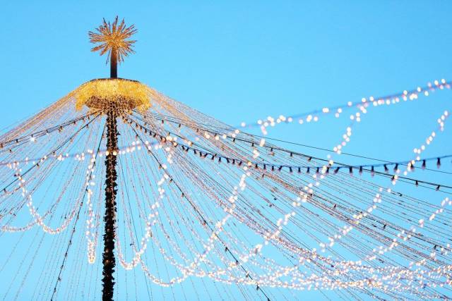 Weihnachtsmarkt Beleuchtung von einem Hauptmast abgehend vor blauem Himmel