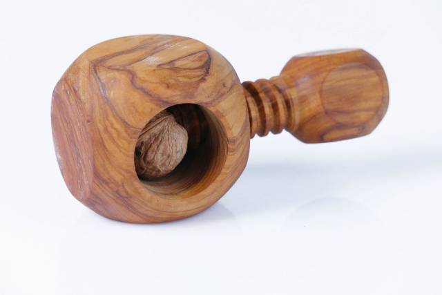 Nussknacker mit einer ganzen Walnuss, vor weißem Hintergrund