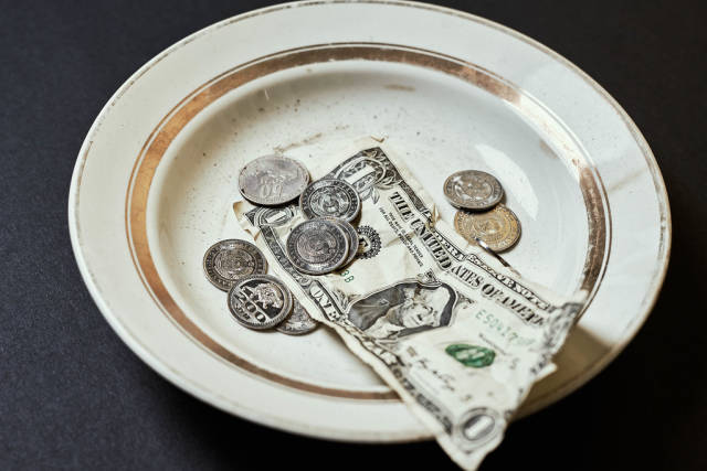 A plate with donated coins and money