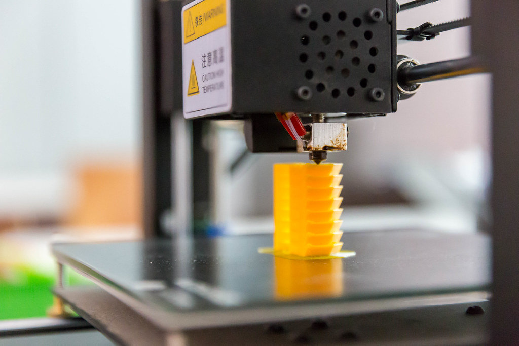 3D printer printing a yellow piece