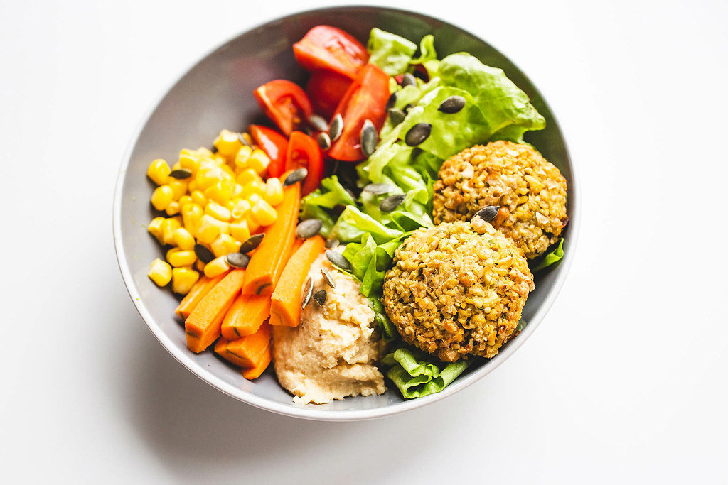 Falafel and vegetables vegan bowl on white background