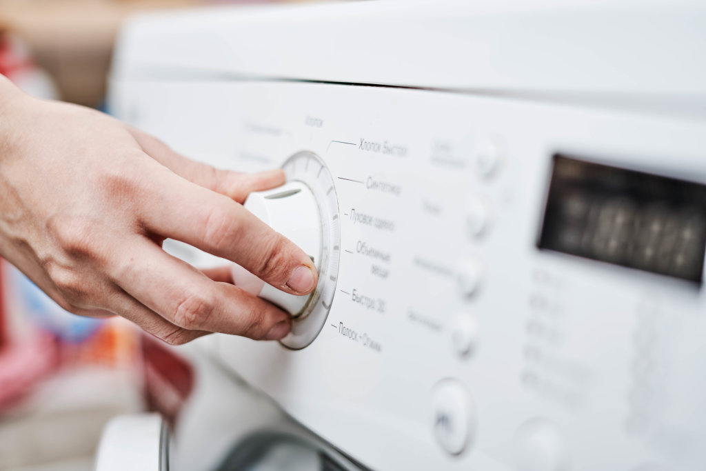 Woman choosing program on washing machine