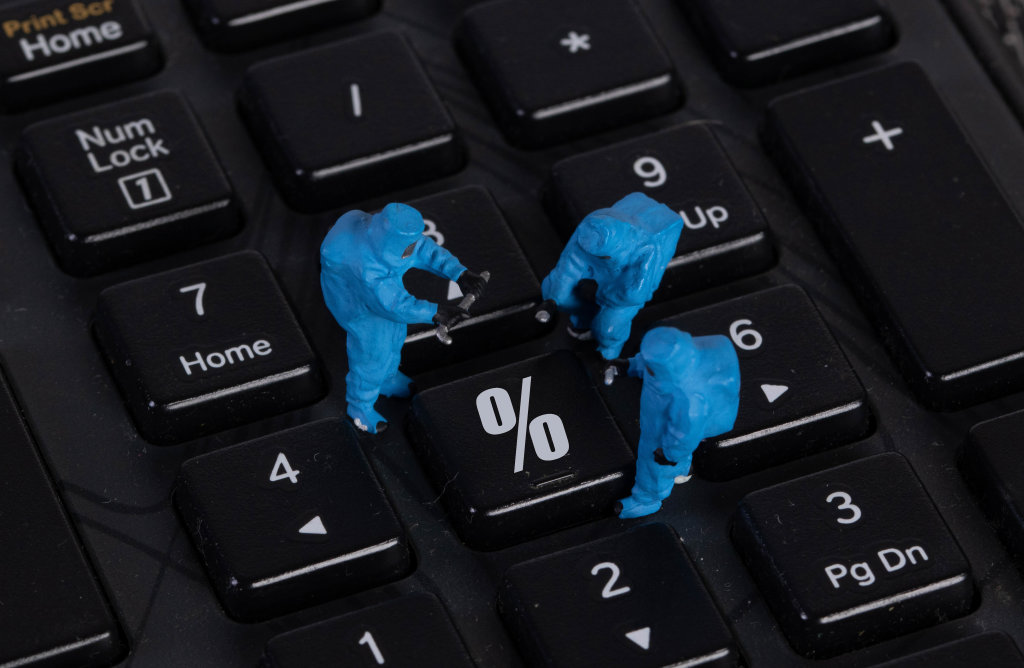 Miniature workers in protective clothes on a keyboard with Percentage button