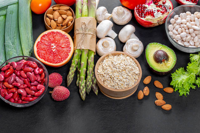 Top View Food Photo of Healthy Ingredients like Red Beans, Oatmeal, Avocado, Almonds, Mushrooms, Asparagus and Grapefruit on Black Background