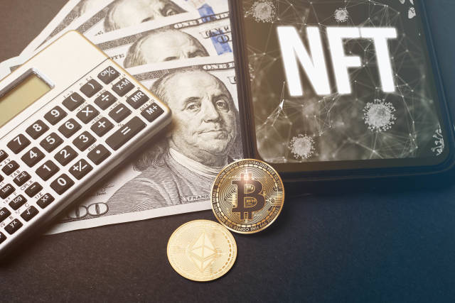 NFT - on the mobile phone screen, calculator, USD dollar bills, bitcoin and ethereum crypto coins on the table