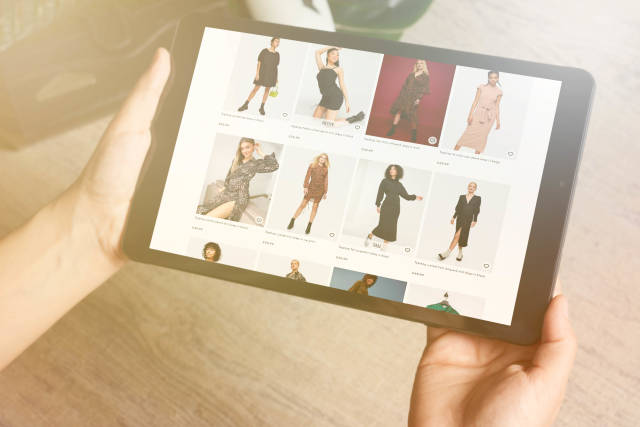E-commerce and online shopping concept - woman choosing clothing