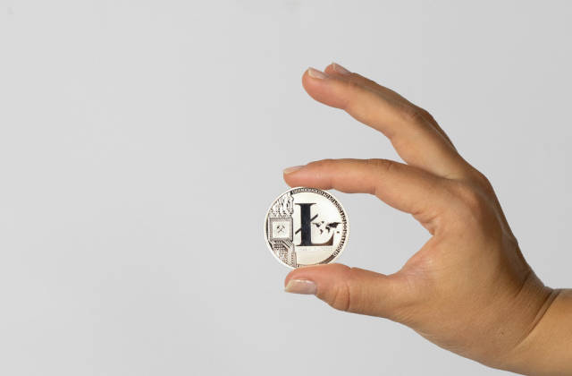 Woman holding a physical  Litecoin