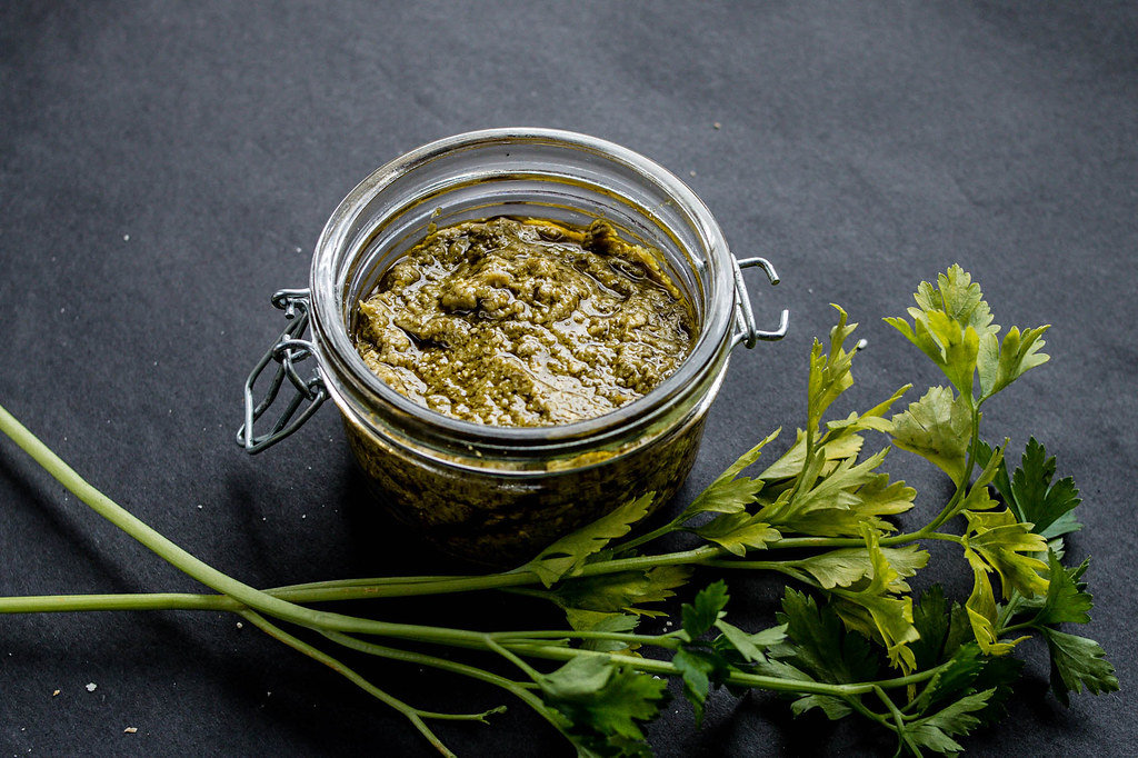 Delicious green pesto in a glass jar.