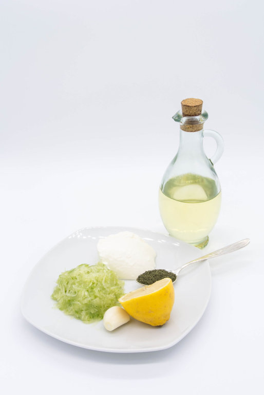 Ingredients for Greek Tzattziki sauce_grated cucumber, lemon juice, oil, sour cream and dill