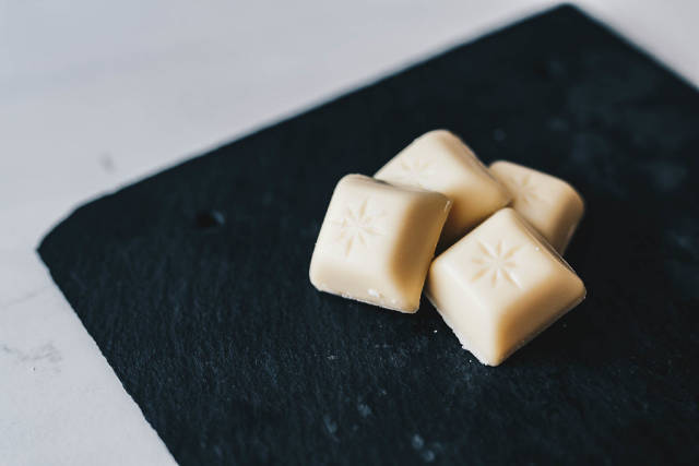 Cubes of white chocolate Schogetten on dark background