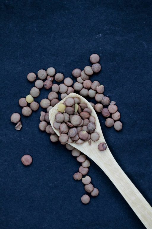 Lens in wooden spoon on dark background