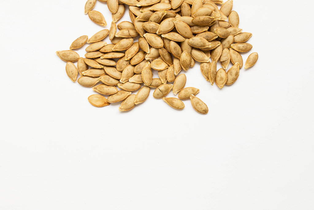 Roasted pumpkin seeds on white background