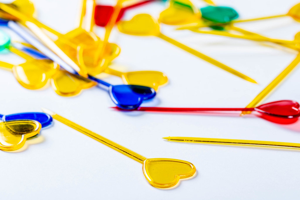 Colorful plastic skewers for food on white background