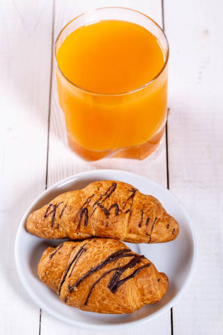 Breakfast with two croissants and fresh juice