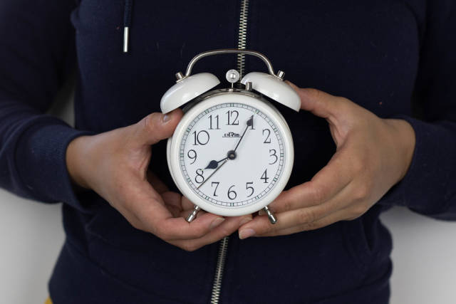 Girl holds alarm clock