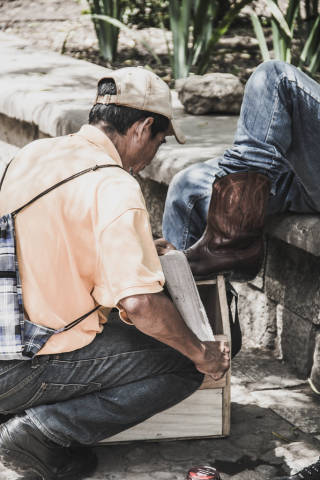 Man Polishing Boots in the Park