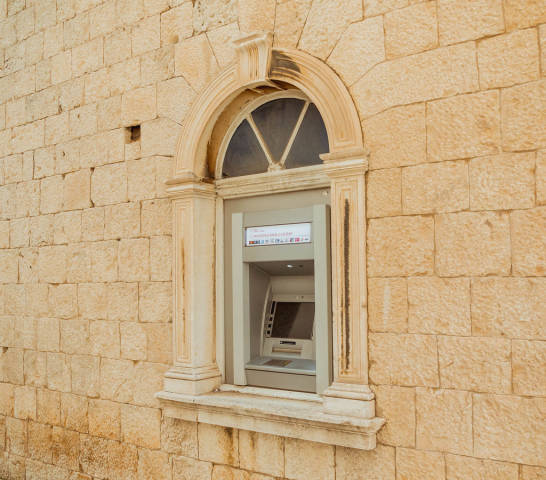 Old outdoor ATM machine on wall