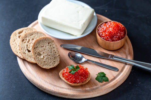 Preparing Breakfast with bread, butter and red caviar