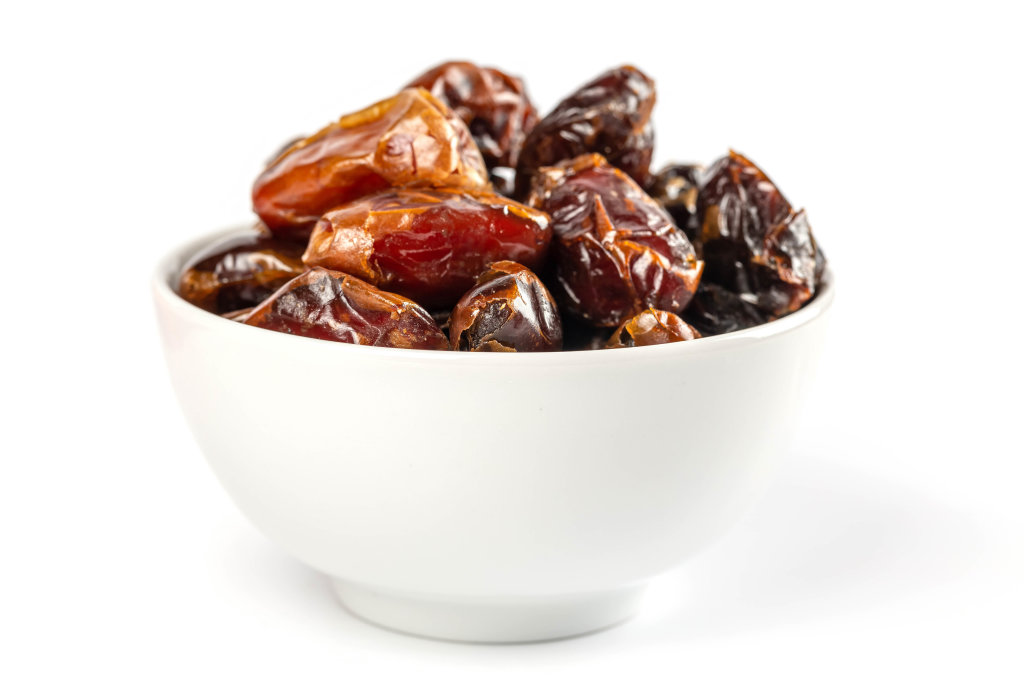 Bowl with dried sweet dates on white